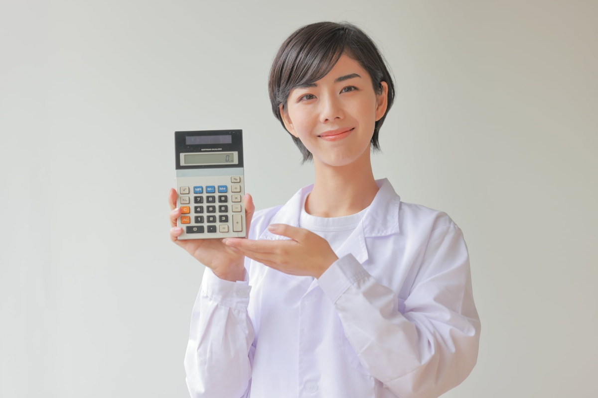 計算機を手にセラミックの費用相場について話す女性